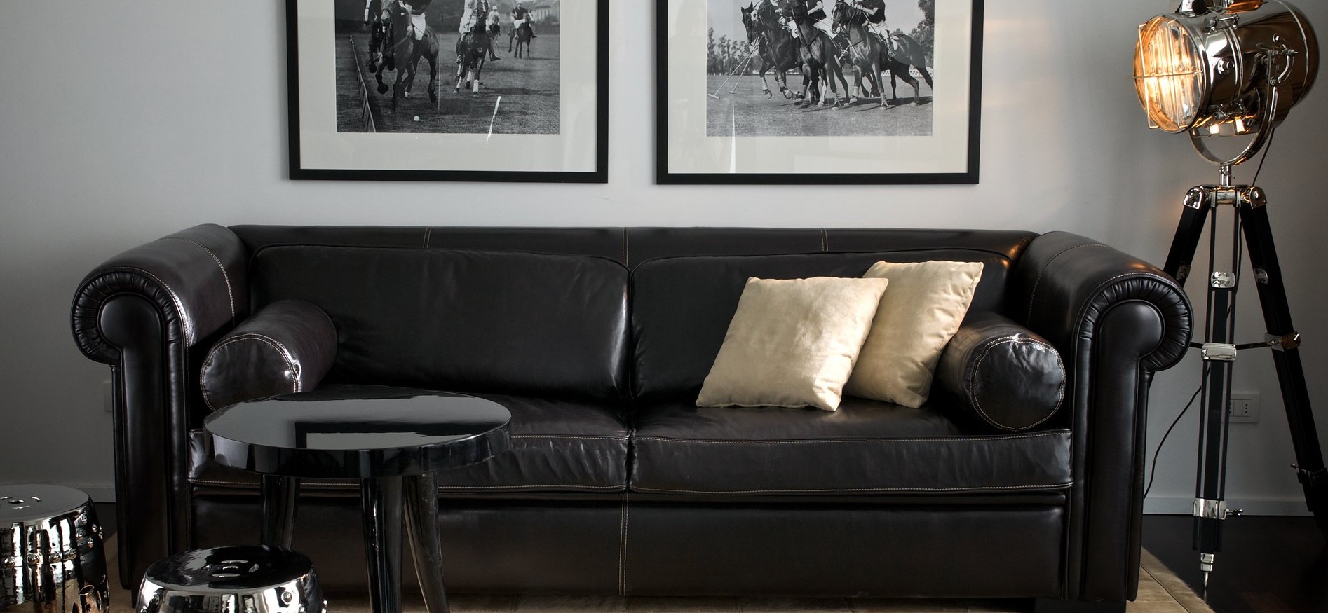 Черный кожаный диван отлично гармонирует с мебелью и декором в интерьере 