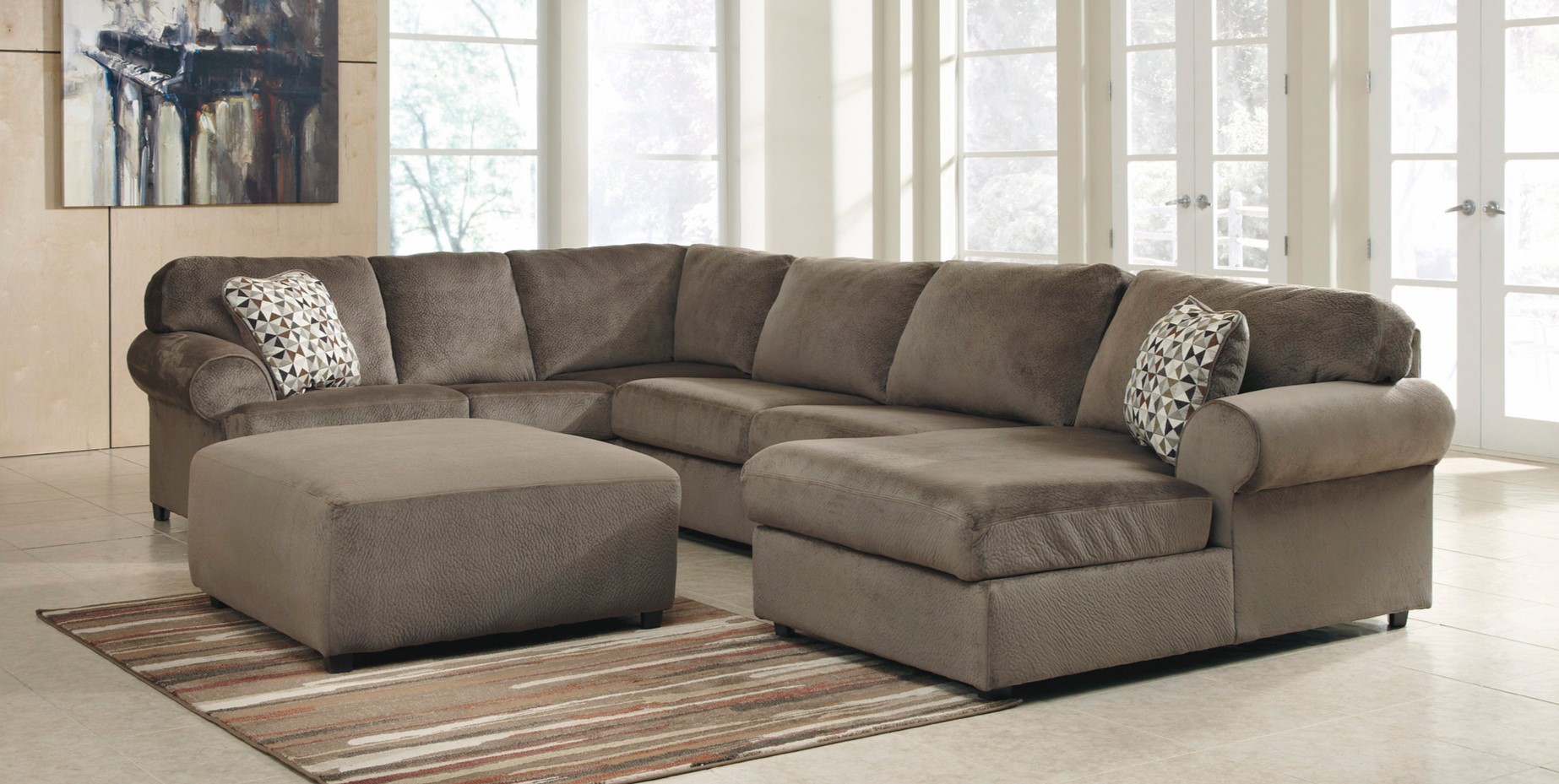 Угловой диван в гостиной можно дополнить стильным пуфом аналогичного цвета