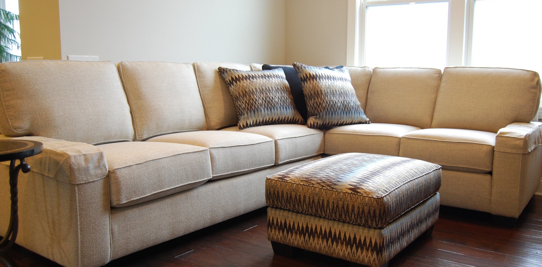 Бежевый диван отлично гармонирует с коричневым полом в интерьере
