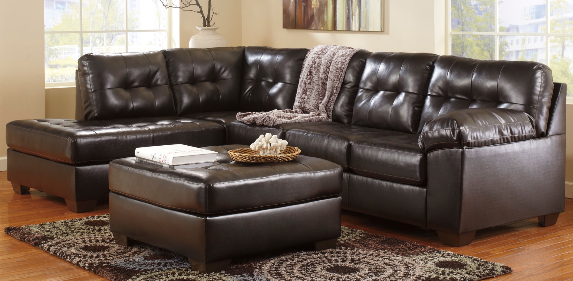 Кожаный темный диван можно использовать в классическом или в современном интерьере