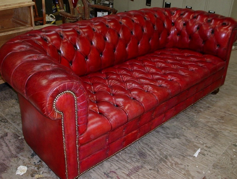 Красный кожаный диван можно использовать в качестве эффектного интерьерного акцента