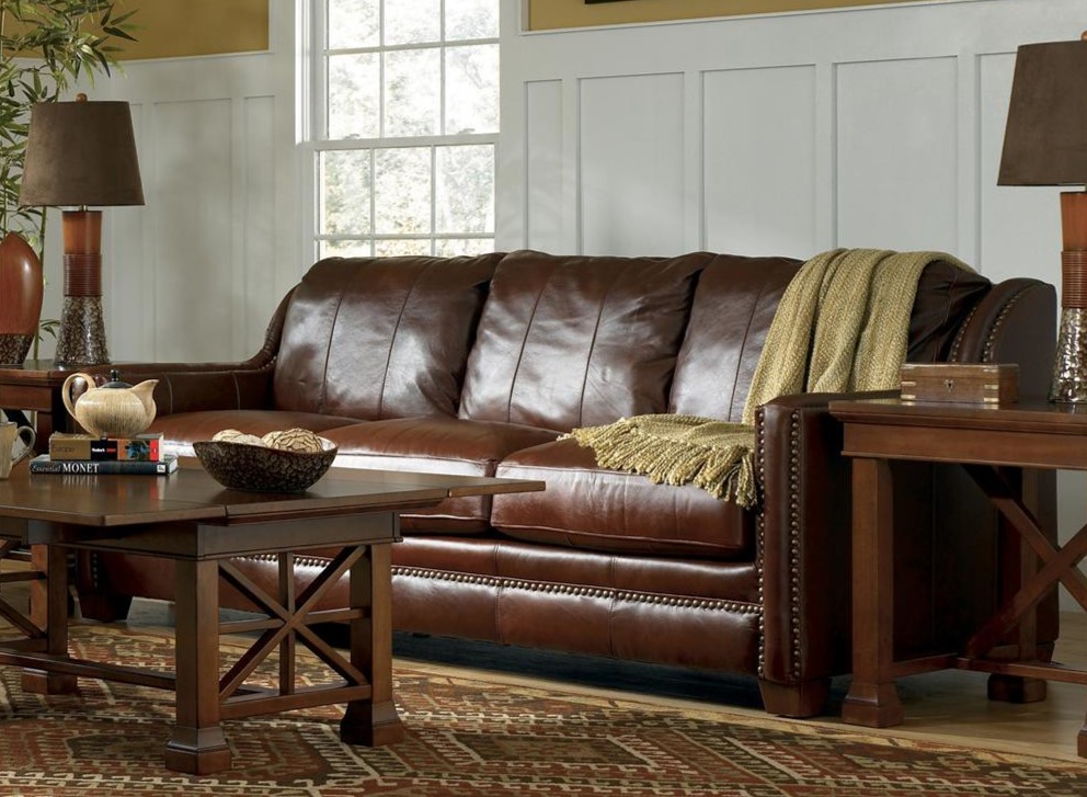 Коричневый кожаный диван идеально сочетается с мебелью из натурального дерева