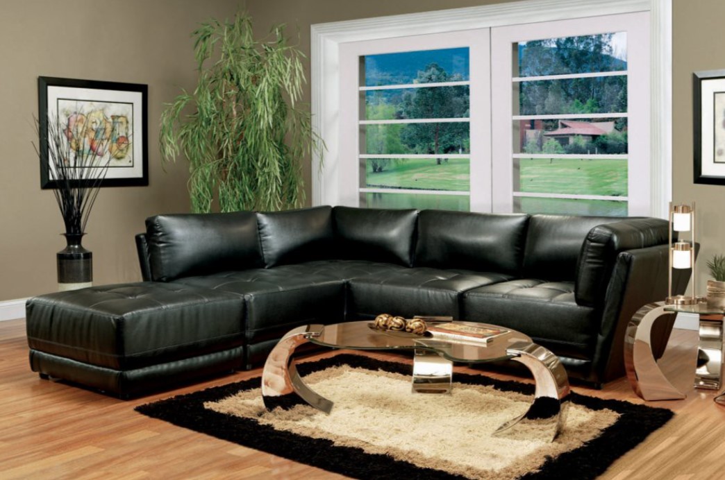 Черный кожаный диван отлично сочетается с металлическим журнальным столиком
