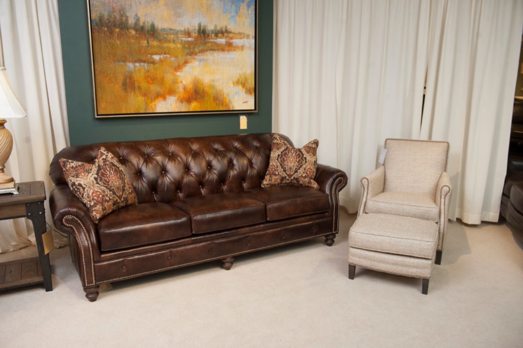 Кожаный коричневый диван с деревянным каркасом можно использовать в домашней библиотеке