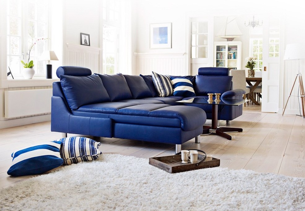 Синий диван можно использовать в качестве интерьерного акцента в белой комнате