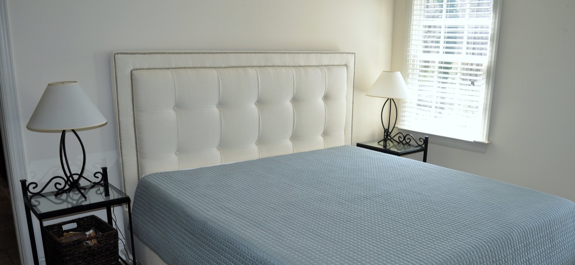 Мягкое белое изголовье кровати подойдет под современный интерьер спальни