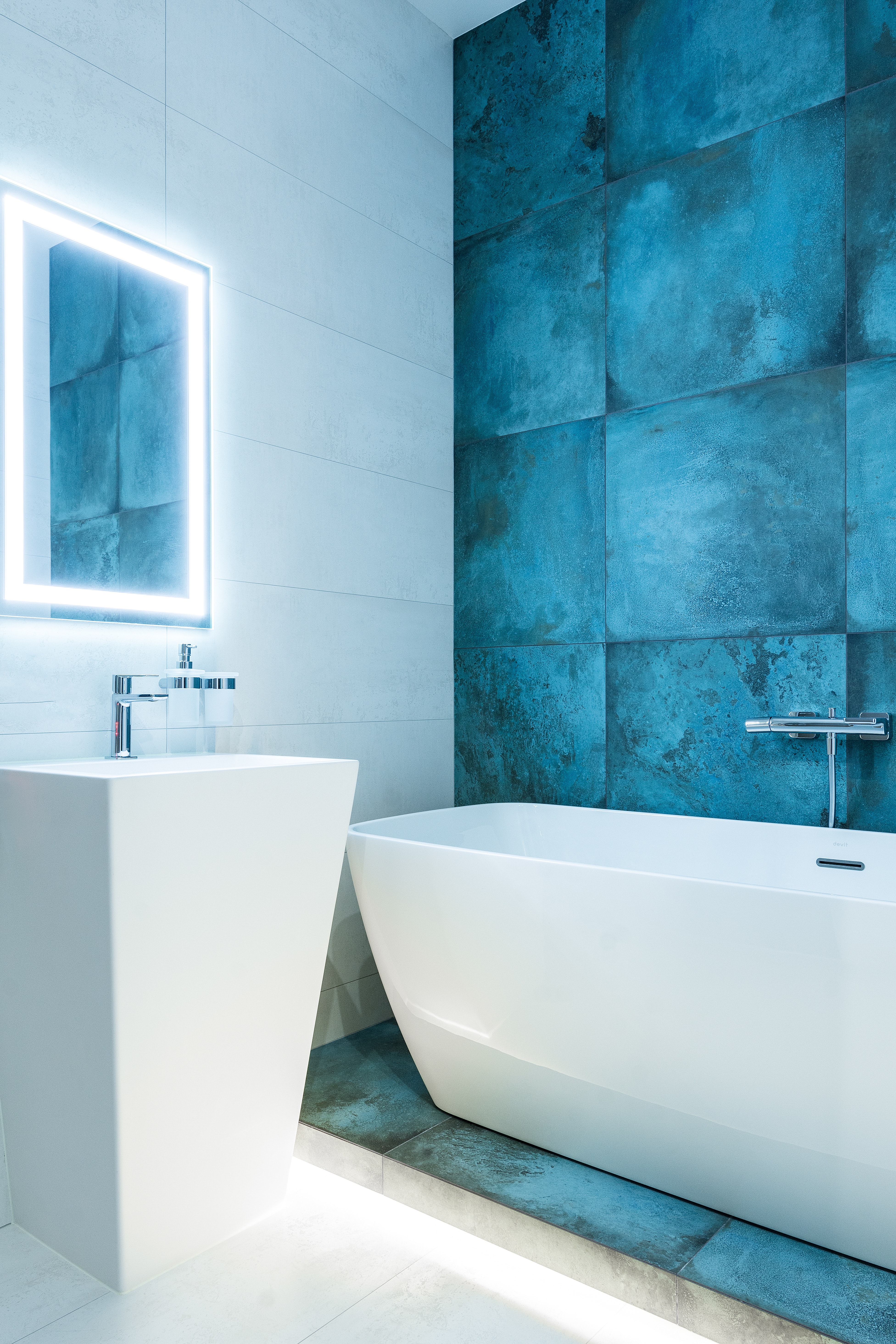 В зеркале отражается цветная стена, яркий дизайнерский акцент для ванной небольшого размера. 