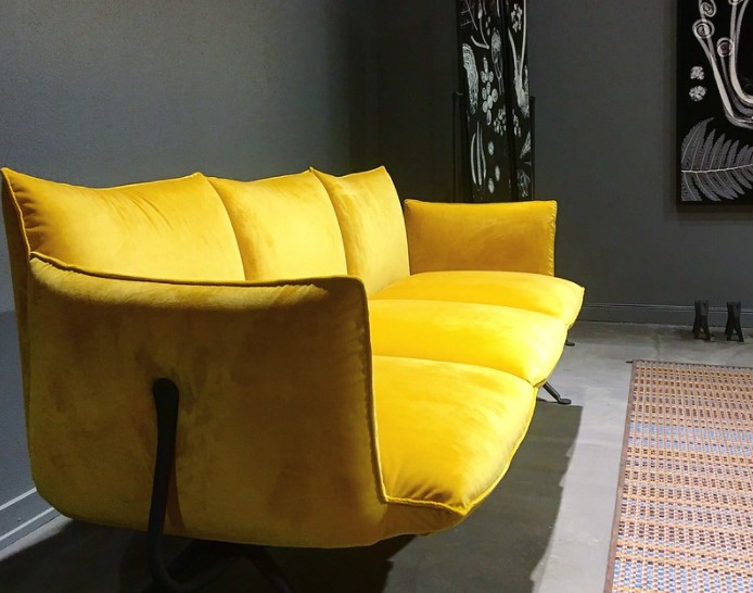 Желтый диван станет ярким акцентом в серой комнате 
