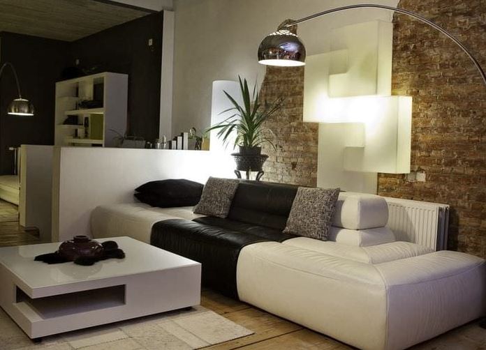Шикарный белый диван оттеняет кирпичная стена и эффектная подсветка