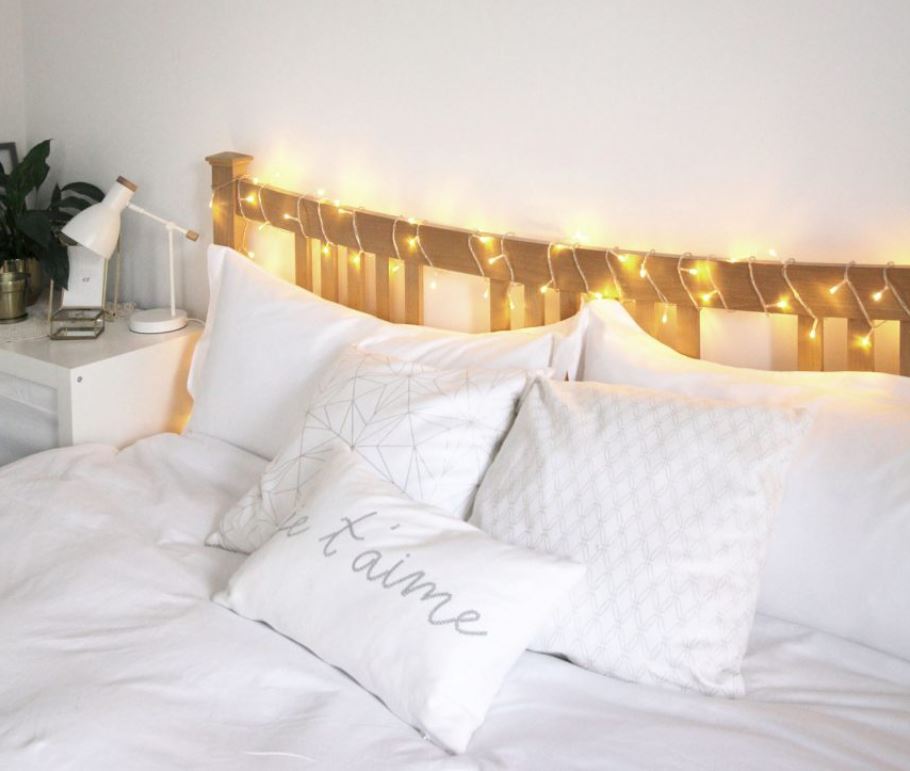 Светодиодная гирлянда в изголовье кровати выполняет функцию декора и освещения