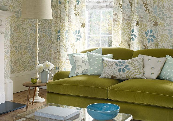 Темно-оливковый цвет дивана перекликается с отделкой стен и текстилем