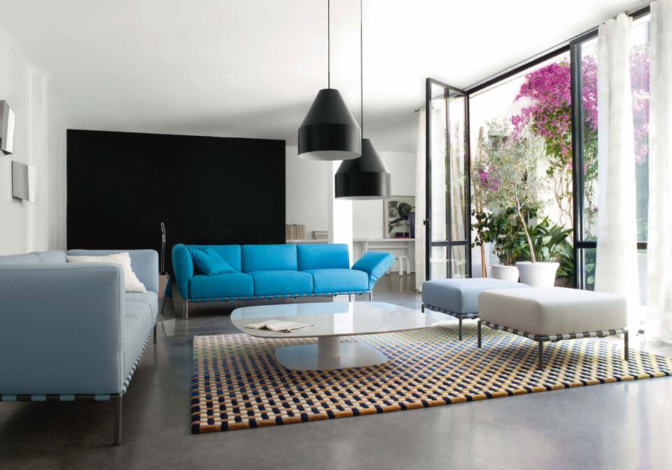 Яркий голубой диван оживляет серую палитру гостиной