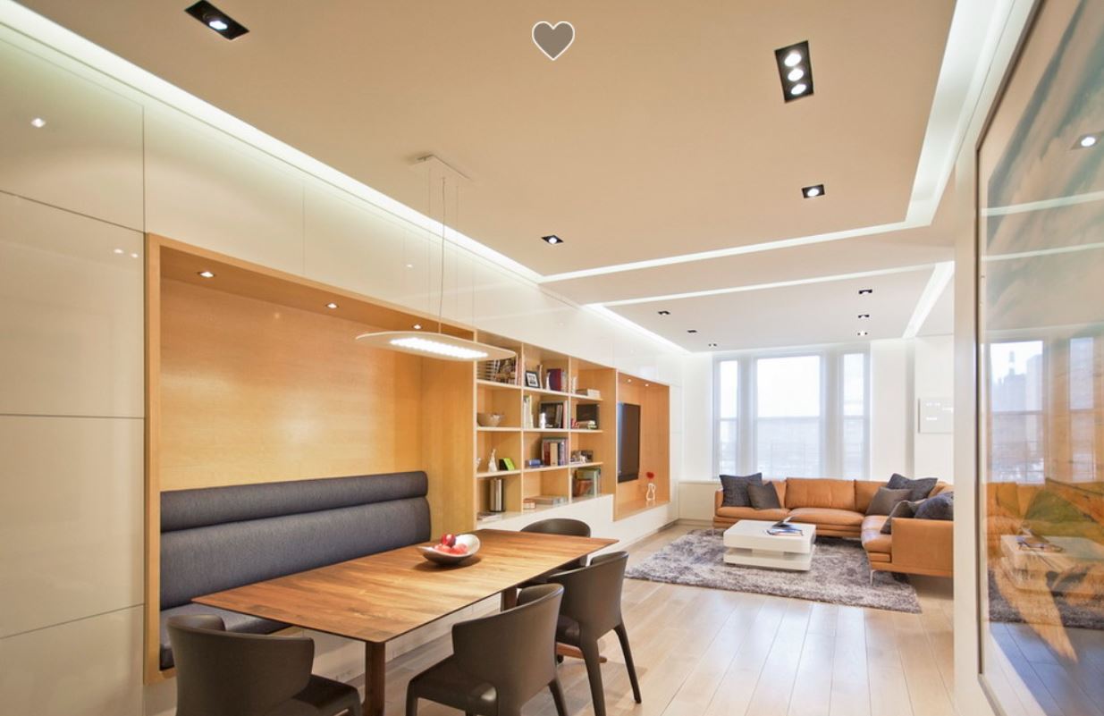 Потолочное пространство с подсветкой разделяет гостиную на зоны
