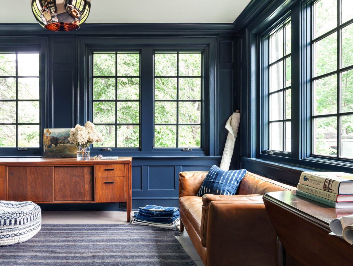 Темно-рыжий кожаный диван и тумба идеально сочетаются с синими стенами