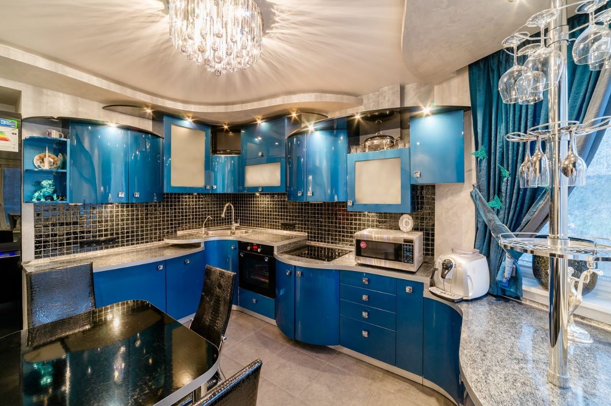Современная кухня с синими глянцевыми фасадами и блеском хромированных деталей и стекла