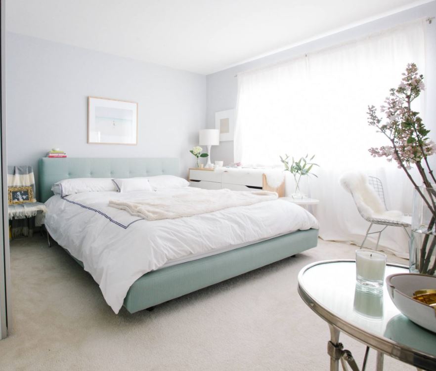 Просторная белая спальня с кроватью цвета мяты