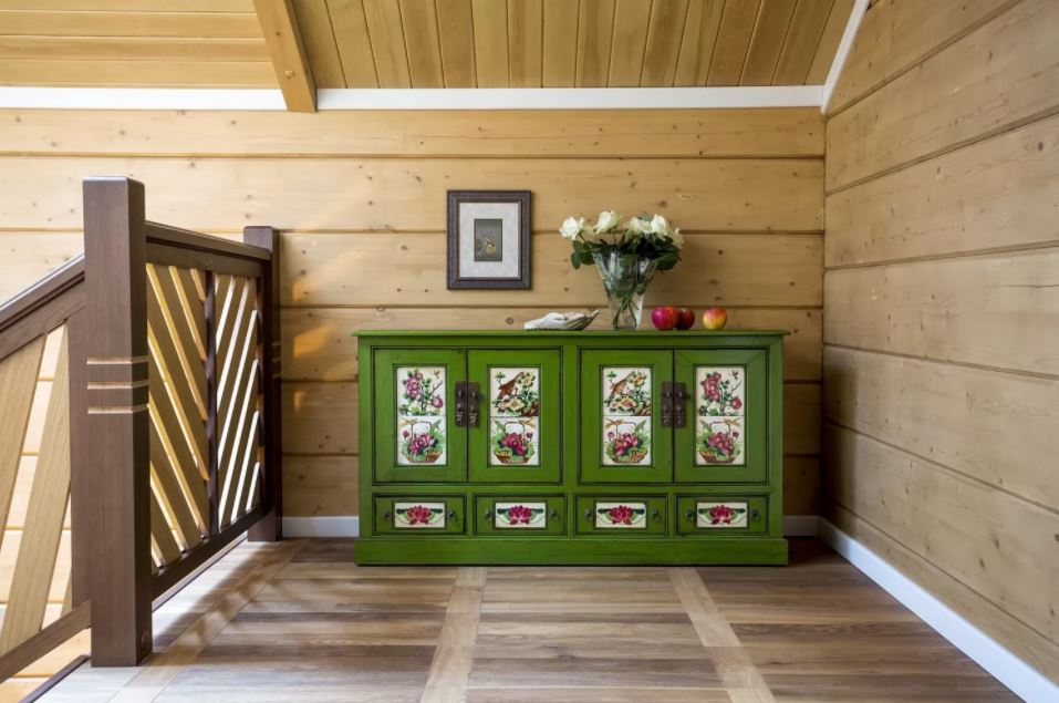 Зеленый комод в коридоре деревянного дома