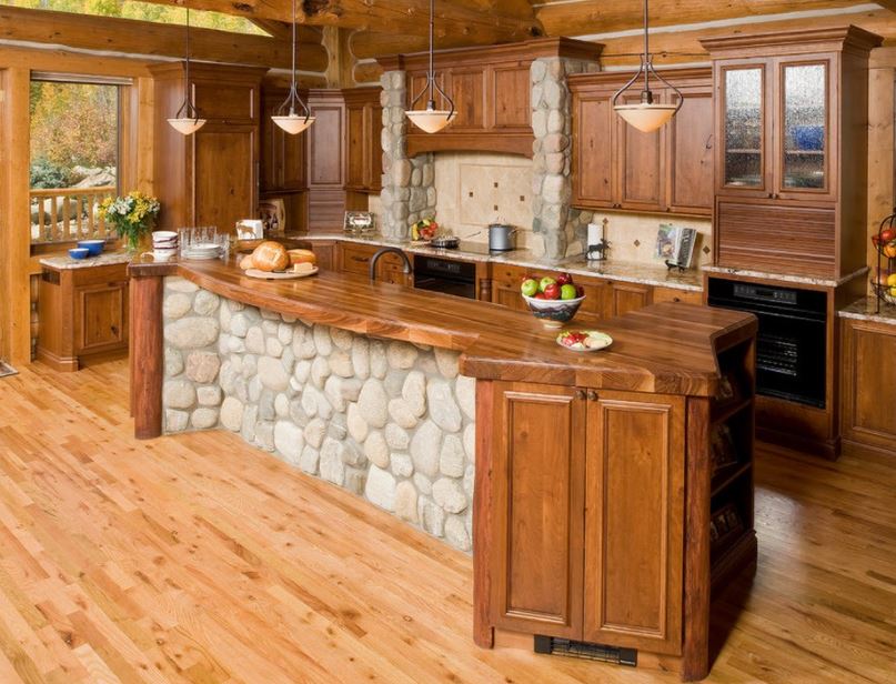 Традиционная кухня загородного дома с деревянной мебелью и оригинальным оформлением крупной галькой