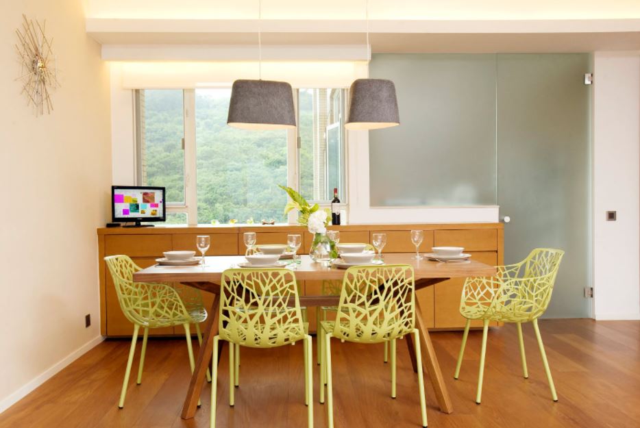 Желтые ажурные стулья придают современный вид столовой зоне