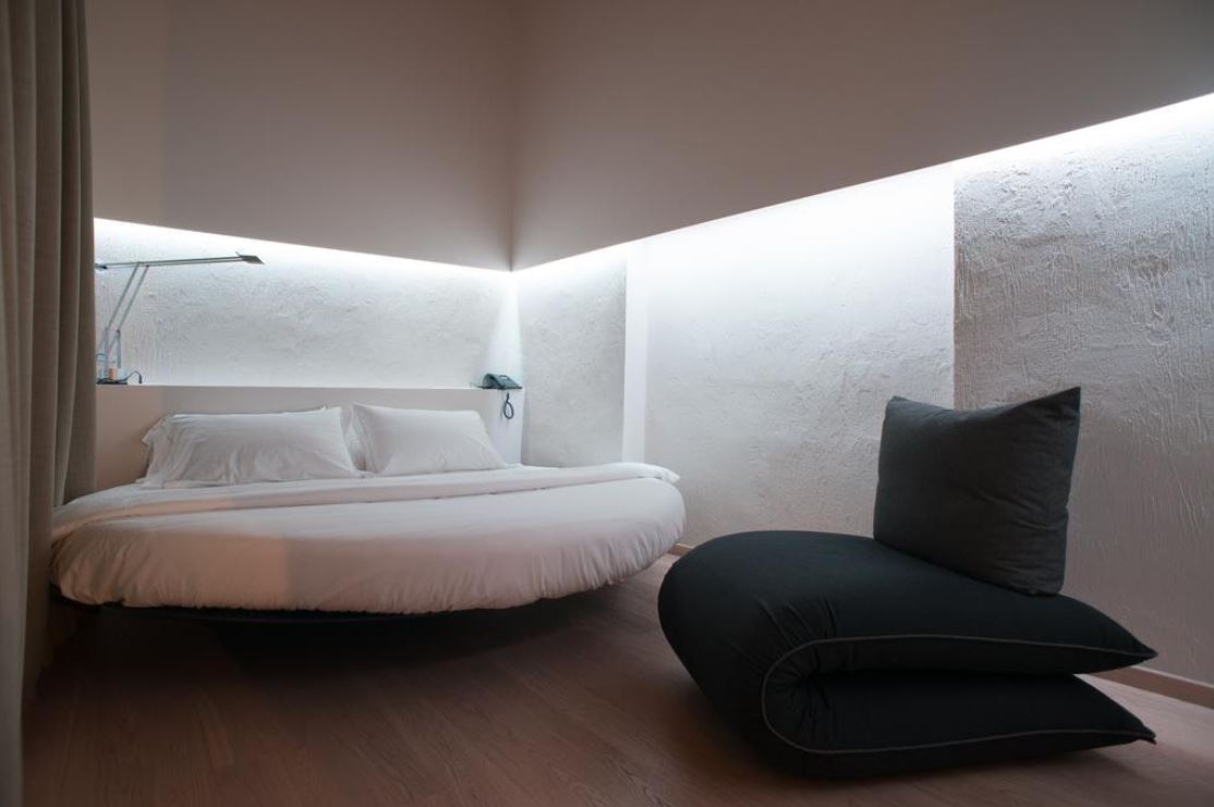 Полукруглая кровать и бескаркасное кресло – единственная мебель в спальне хай-тек