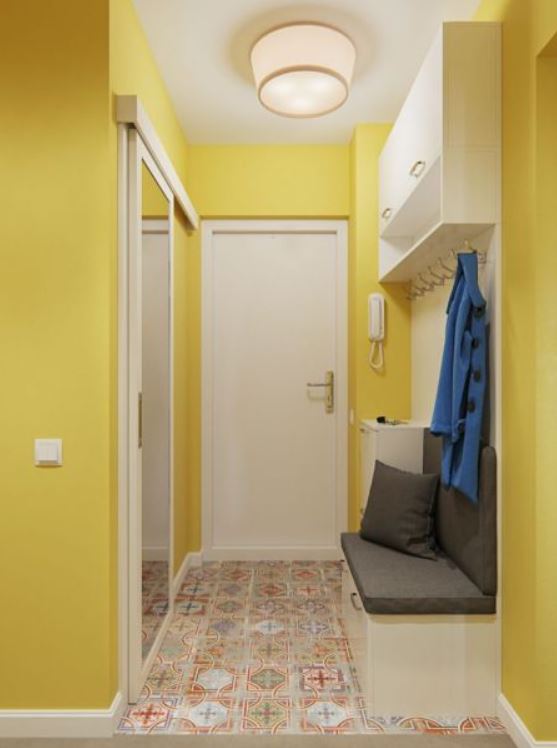 Желтые крашеные стены добавят света в маленькой прихожей, а пестрая плитка на полу скроет мелкие недочеты
