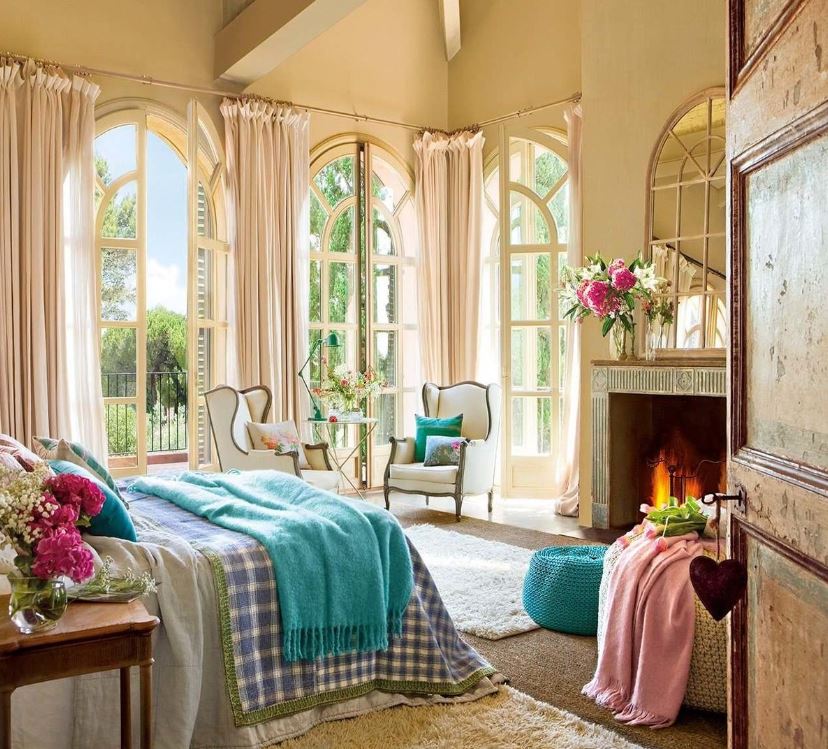 Цветной текстиль пастельных оттенков освежает бежевый интерьер спальни